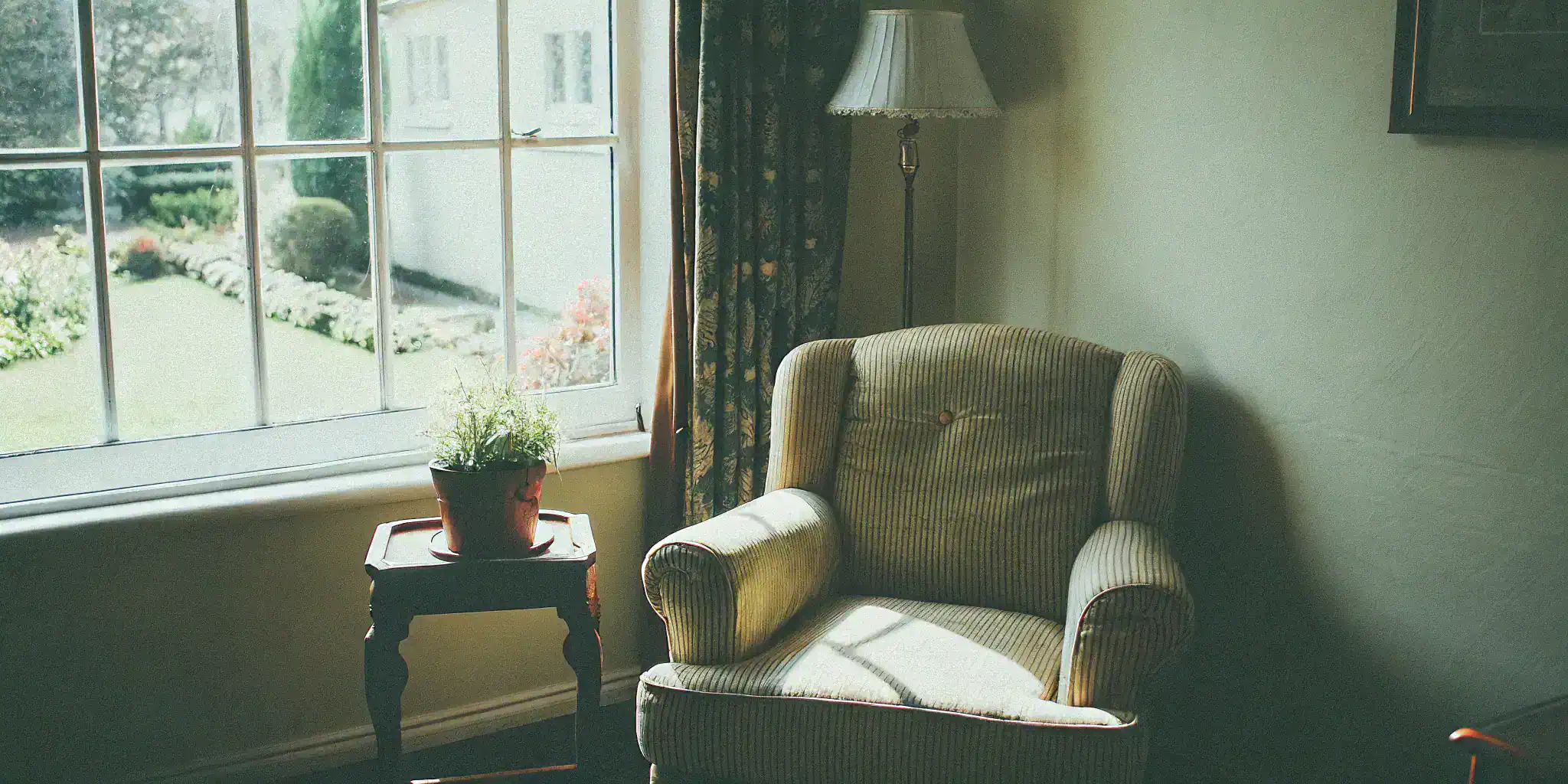 Comfortable living room for a senior deciding between home care and assisted living.